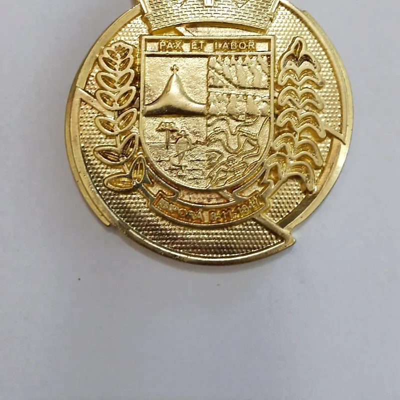 Medalha comemorativa com brasão em relevo e acabamento dourado