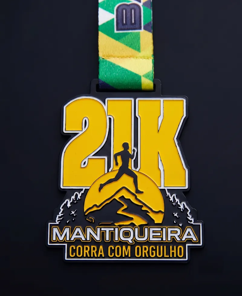 Medalha de 21K com corredor e montanhas em amarelo sobre fundo escuro